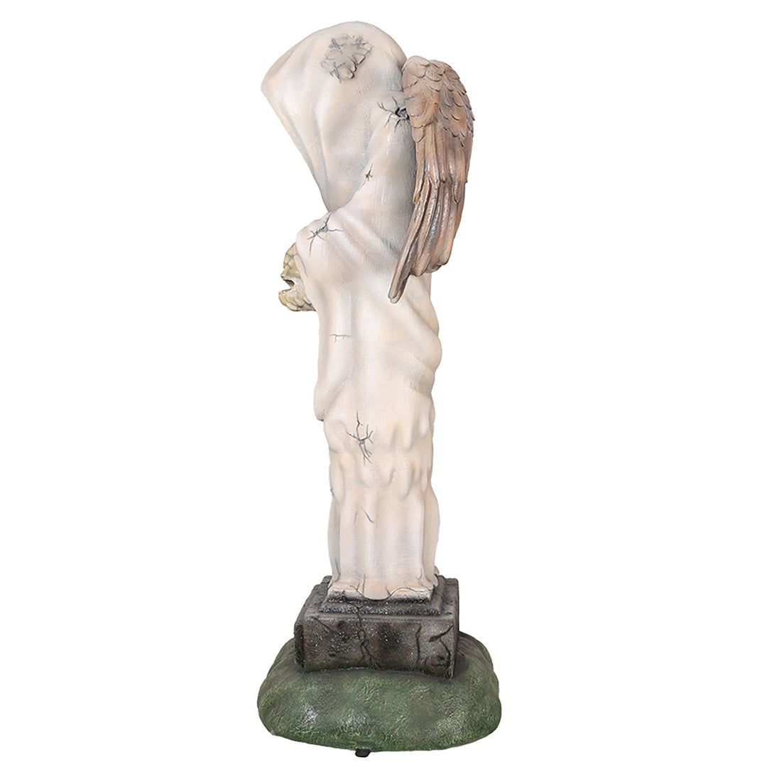 A faceless angel  statue holding a human head facing side