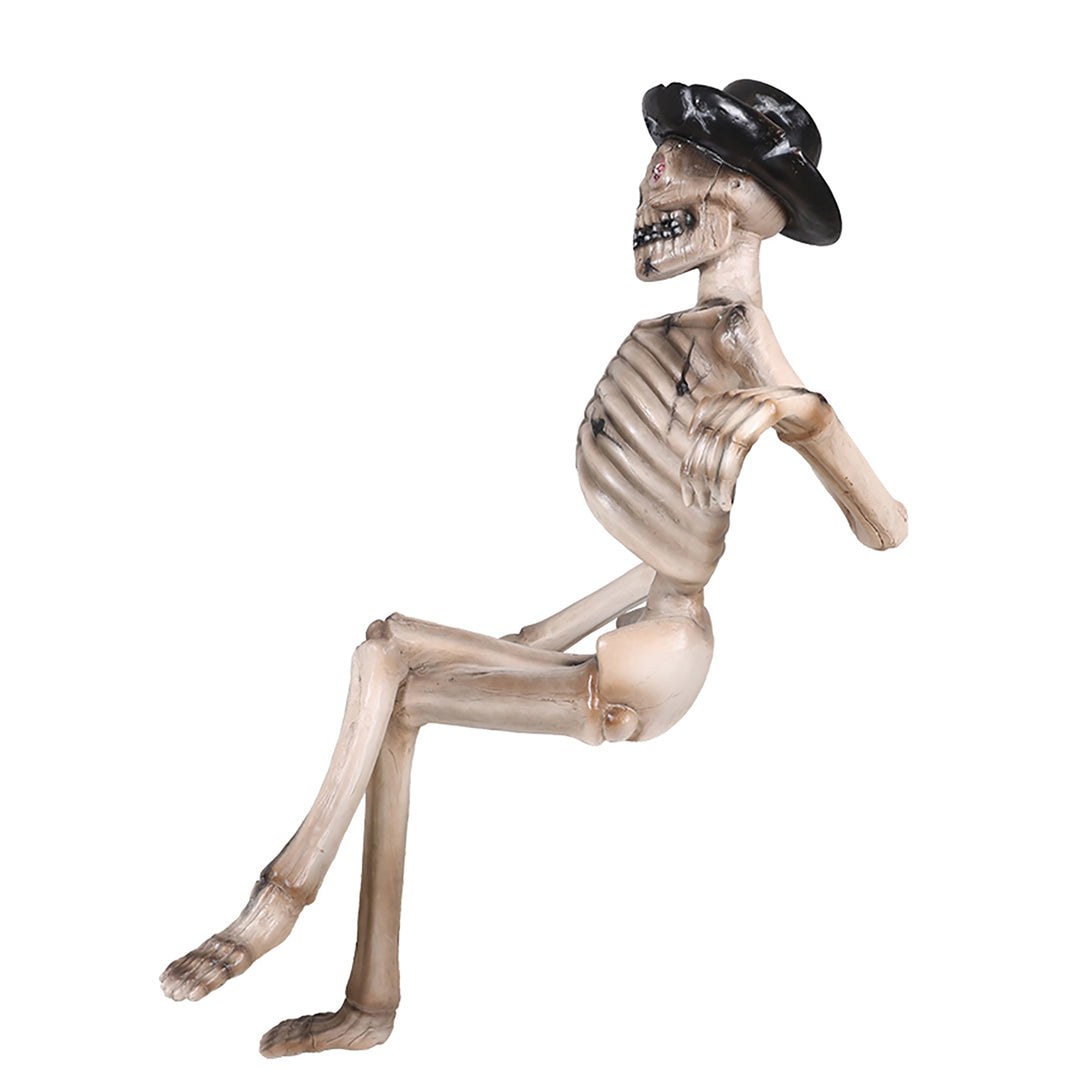 A skeleton sitting on a bench wearing a hat side view